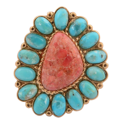 Ring with turquoise stones and a pink central stone on a white background