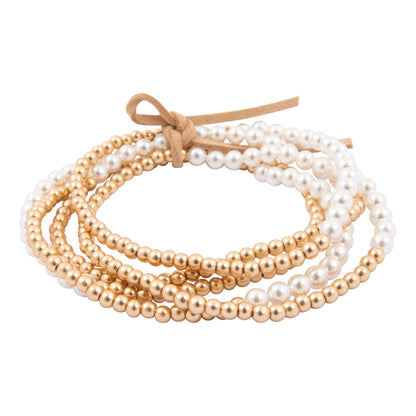 Set of pearl and gold beaded bracelets tied together on a white background