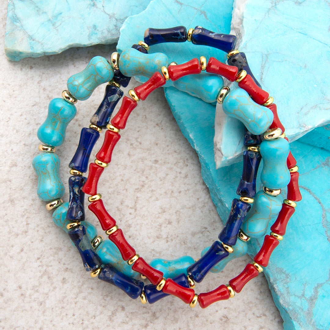 Colorful beaded bracelet with turquoise, red, and blue beads on a textured surface.