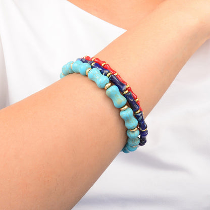 Multicolored beaded bracelet on a wrist against a white background