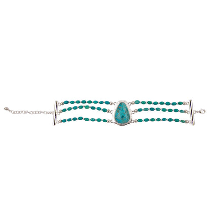 A silver multi-strand bracelet featuring rows of small turquoise beads and a central teardrop-shaped turquoise stone, displayed on a clean white background.
