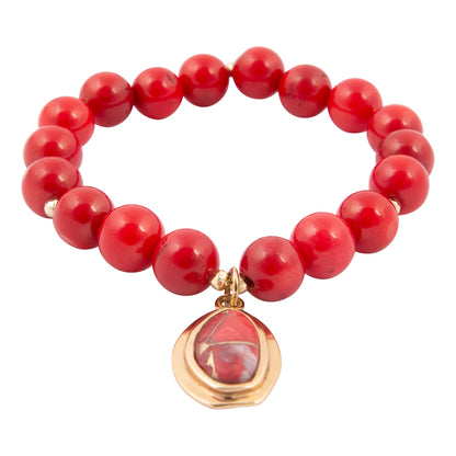 Red beaded bracelet with a gold and red pendant on a white background