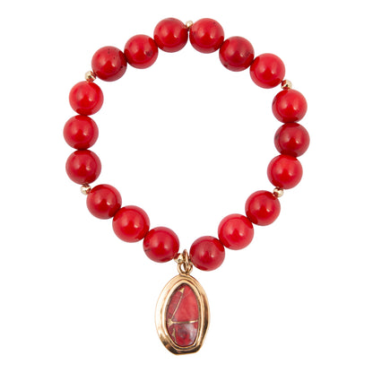 Red beaded bracelet with a gold pendant on a white background