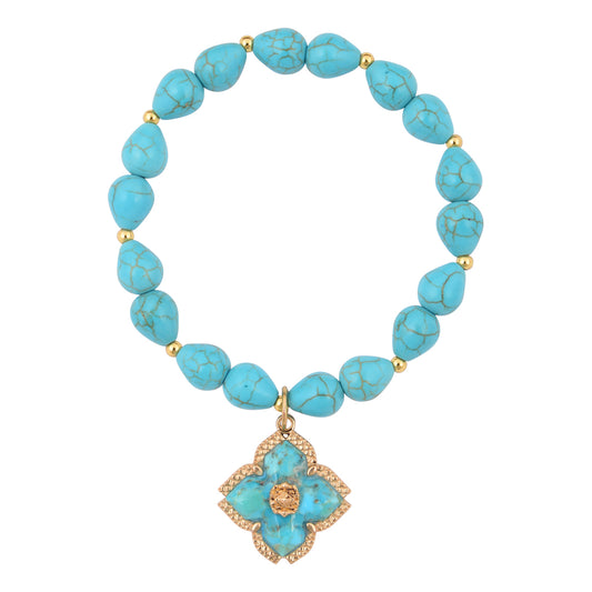 Turquoise beaded necklace with a gold flower pendant on a white background