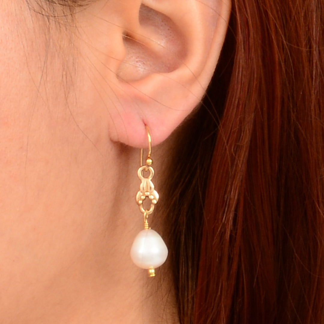 Pearl earring worn by a person with red hair