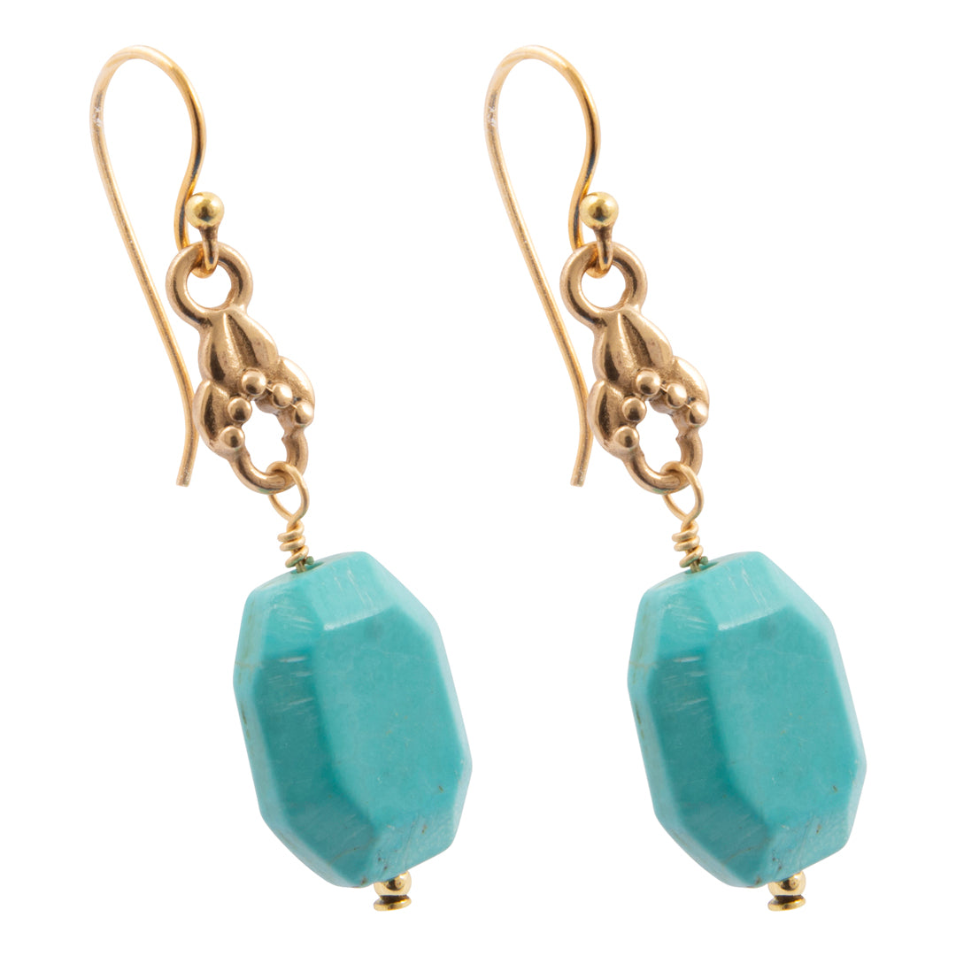 Gold earrings with turquoise beads on a white background