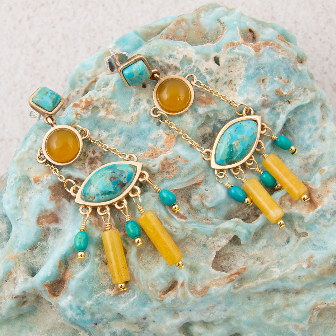 Gold bracelet with turquoise and yellow beads on a textured stone surface
