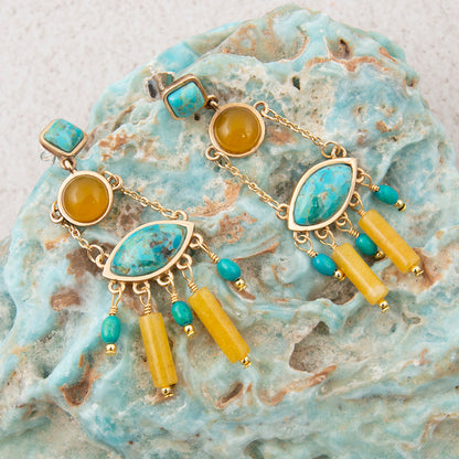 Gold bracelet with turquoise and yellow beads on a textured stone surface