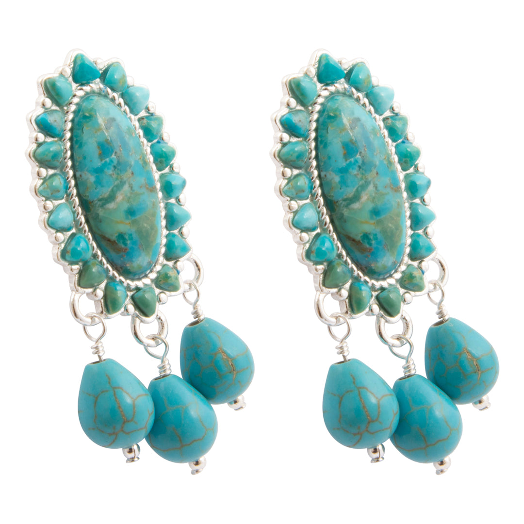 A pair of silver-toned dangle earrings featuring oval turquoise-blue stone centers surrounded by small turquoise beads, with three dangling turquoise teardrop beads at the bottom, shown on a plain white background.