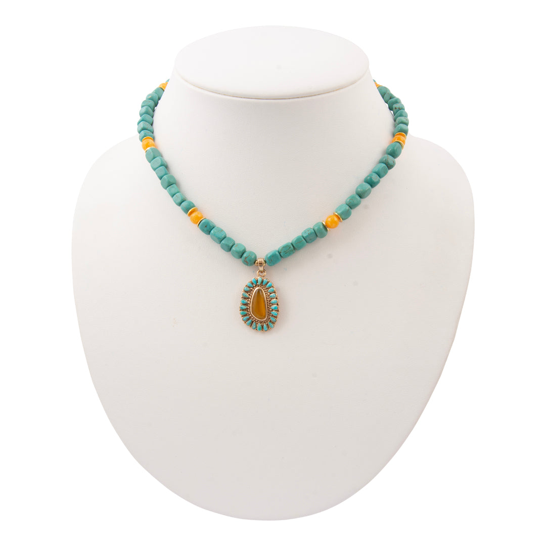Turquoise beaded necklace with a yellow pendant on a white mannequin bust.