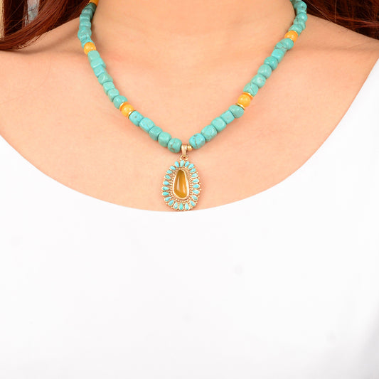 Turquoise beaded necklace with a pendant on a white background