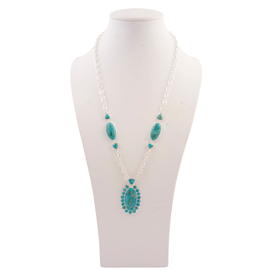 Turquoise necklace on a white mannequin bust against a white background