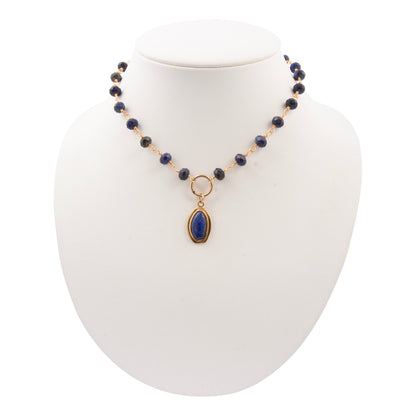 Necklace with blue beads and a gold pendant on a white mannequin bust.