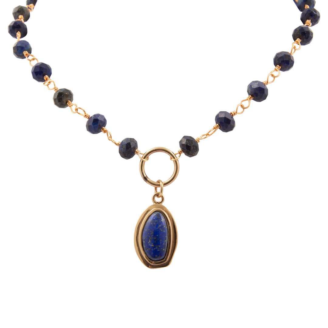 Necklace with dark blue beads and a gold pendant on a white background