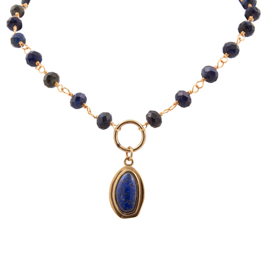 Necklace with dark blue beads and a gold pendant on a white background