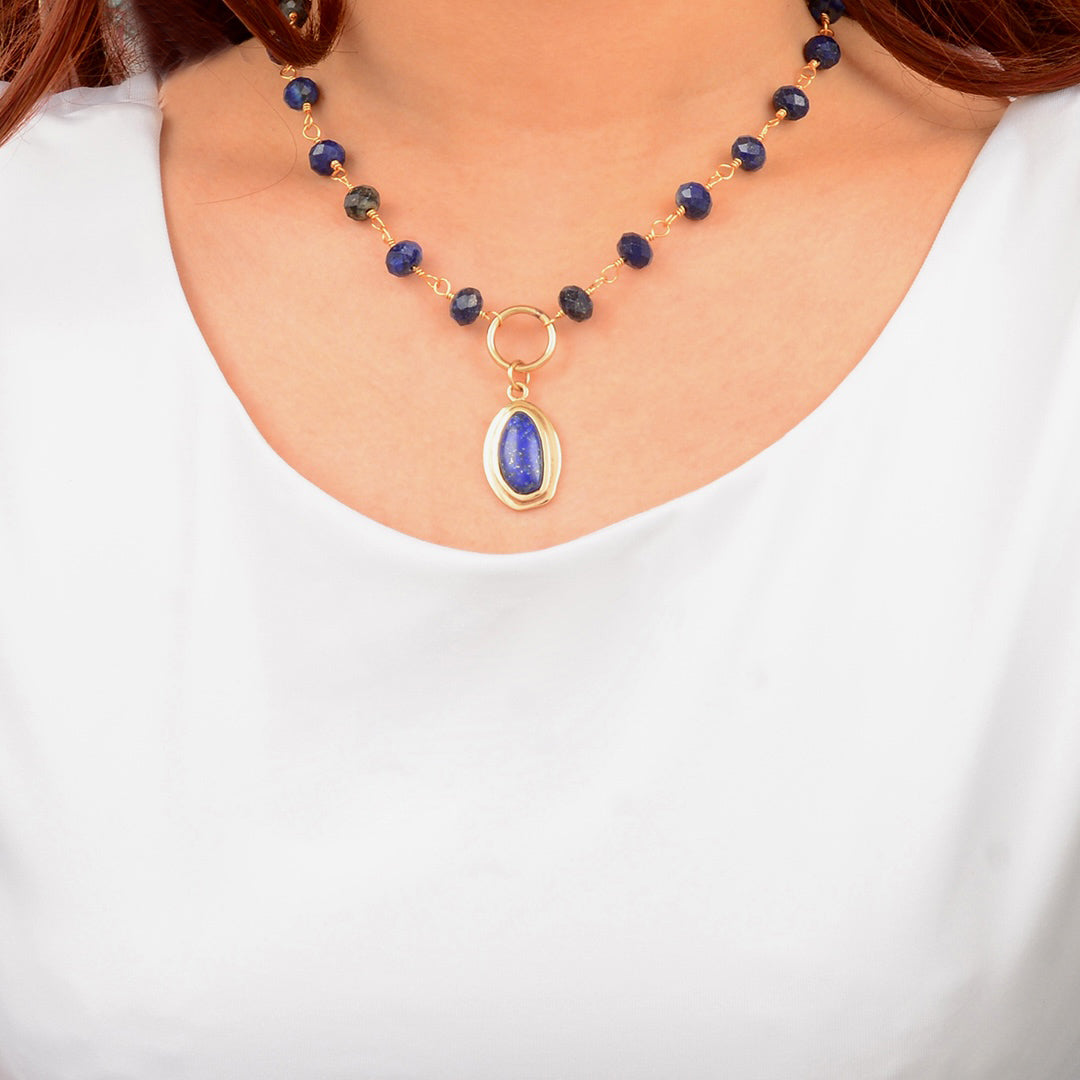 Necklace with blue beads and a gold pendant on a white background