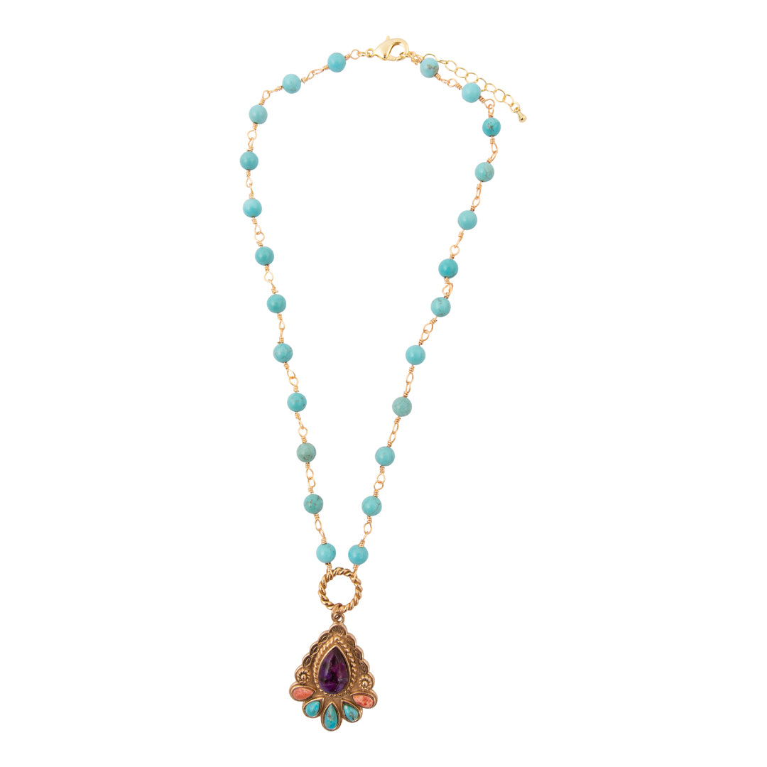 Necklace with turquoise beads and a gold pendant on a white background