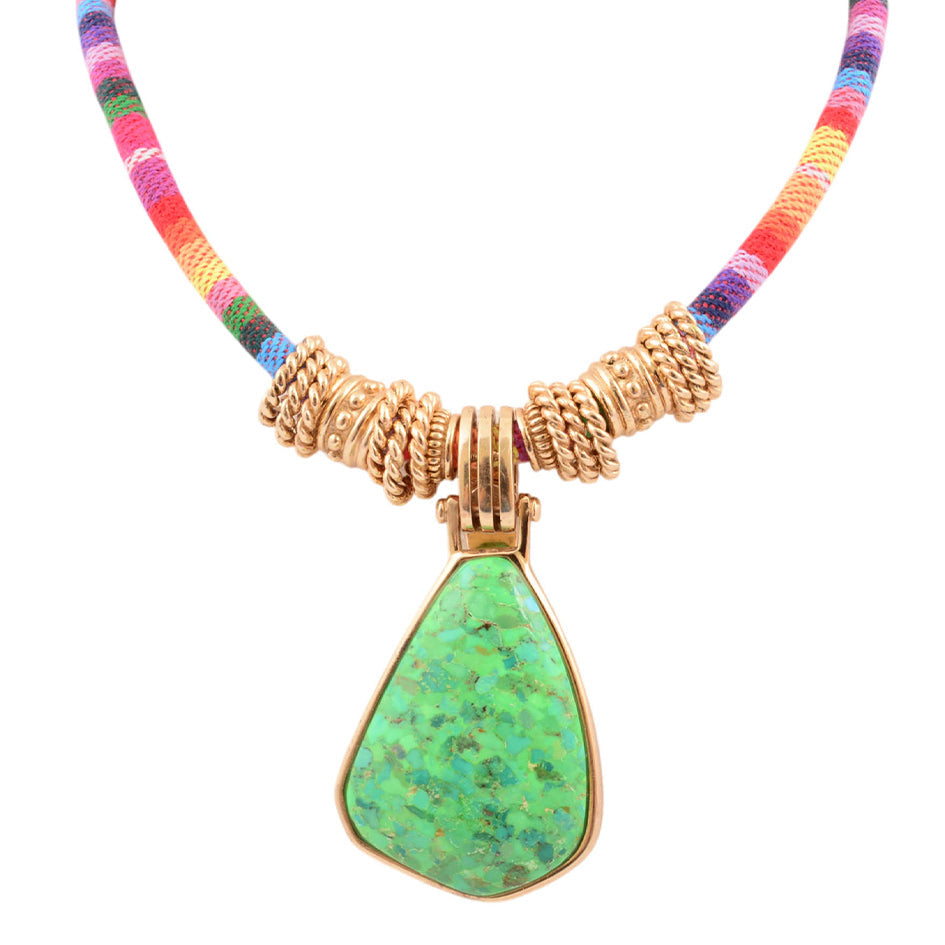 Necklace with a green pendant and gold accents on a white background