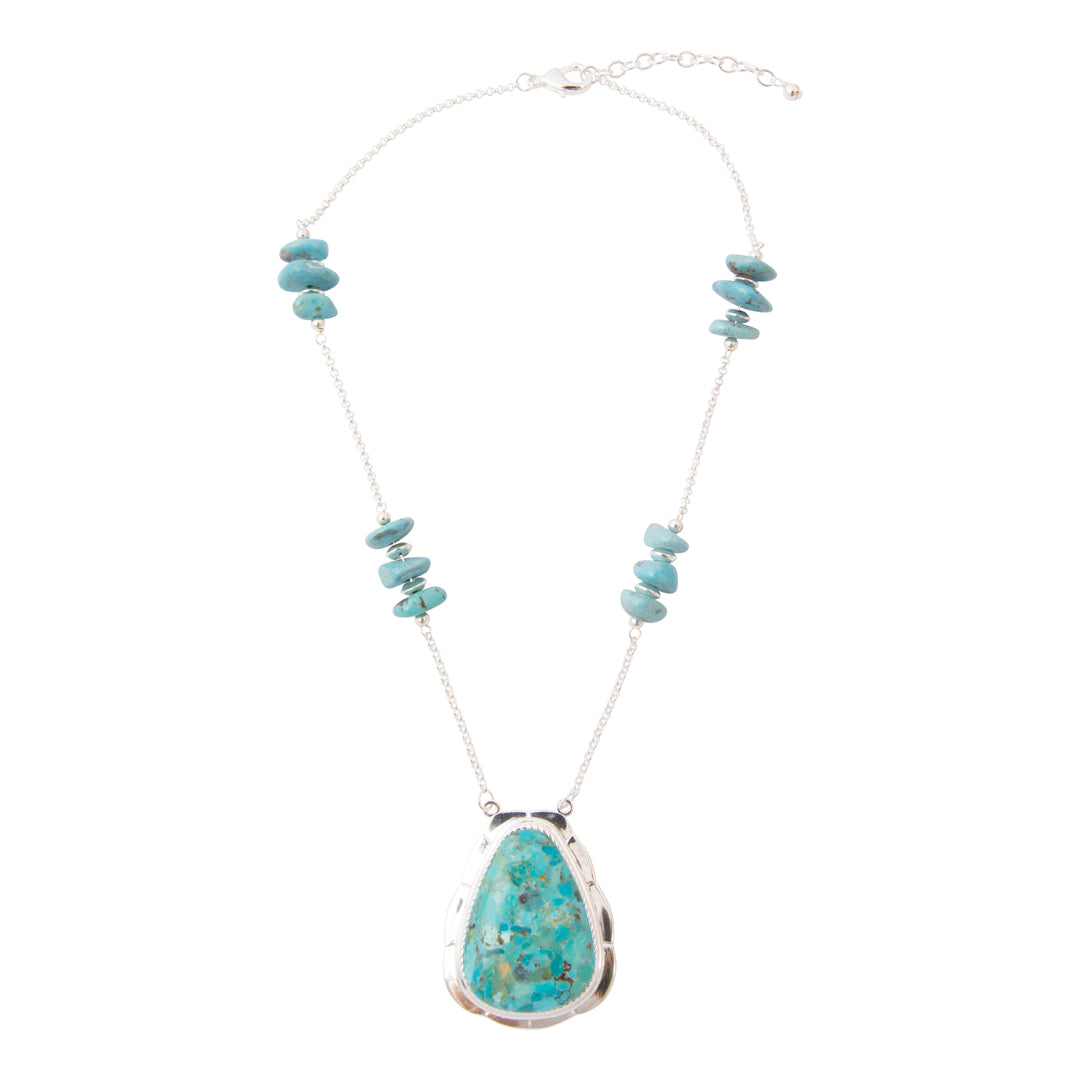 A silver chain necklace featuring a large teardrop-shaped turquoise pendant and smaller turquoise stone bead clusters on the chain, displayed against a solid white background.