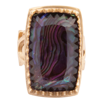 Ring with a gold band and purple abalone shell inlay on a white background