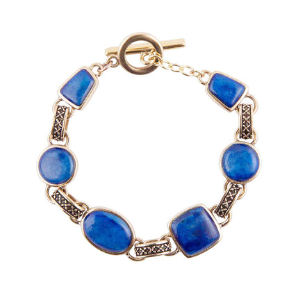 A gold-tone link bracelet featuring alternating oval and rectangular blue stone beads, with textured dark metal connectors and a toggle clasp, shown on a plain white background.