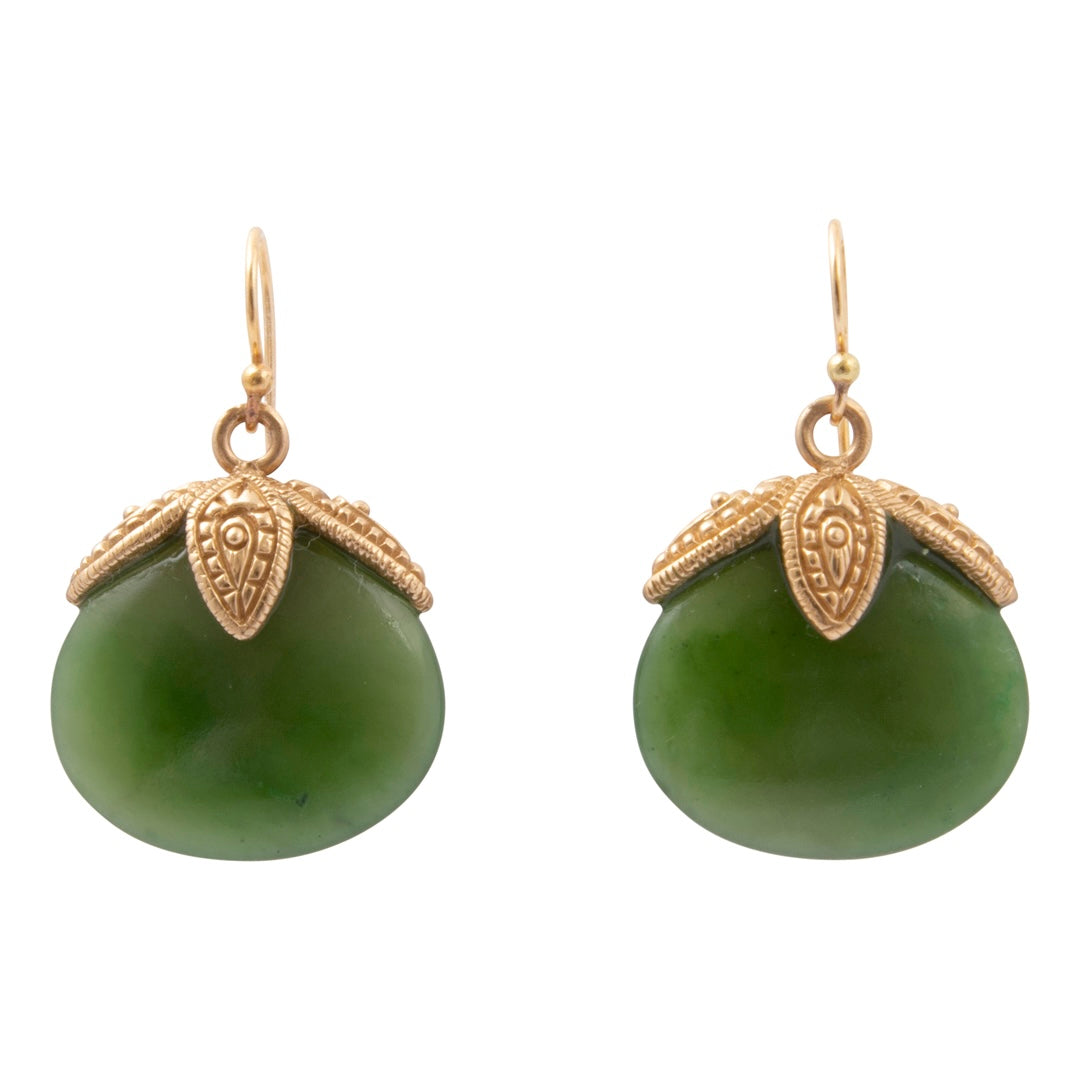 A pair of gold and green drop earrings on a plain white background. Each earring features a smooth, oval-shaped green stone pendant capped with an ornate, textured gold leaf-like setting and a gold fishhook ear wire.