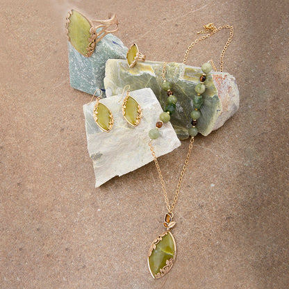 Jewelry set with necklace and earrings on a stone surface