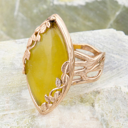 Gold ring with a green stone on a textured surface