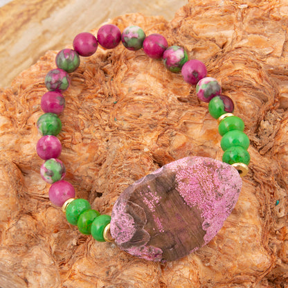 Bracelet with pink and green beads on a textured surface