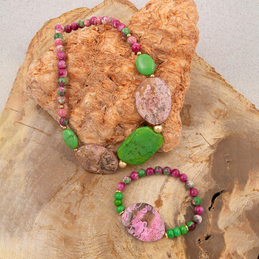 Two beaded bracelets with colorful stones on a textured stone surface
