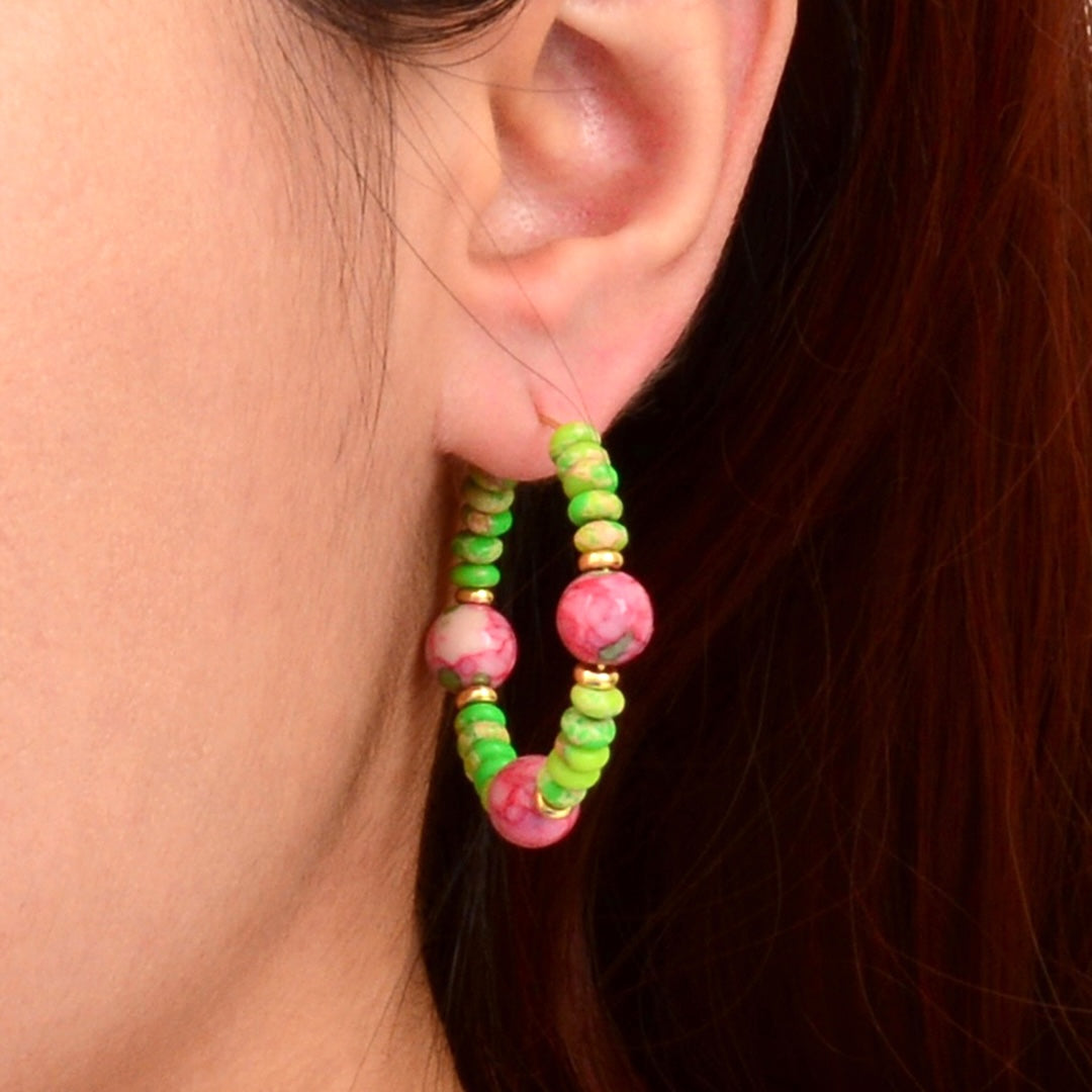 Close-up of an ear wearing colorful beaded hoop earrings.