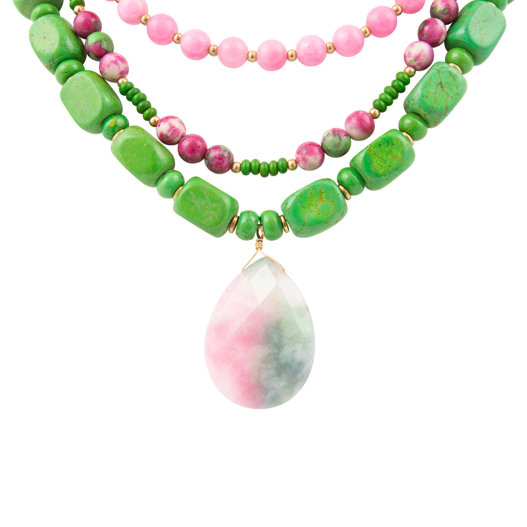 Necklace with green and pink beads and a teardrop-shaped pink and green stone on a white background