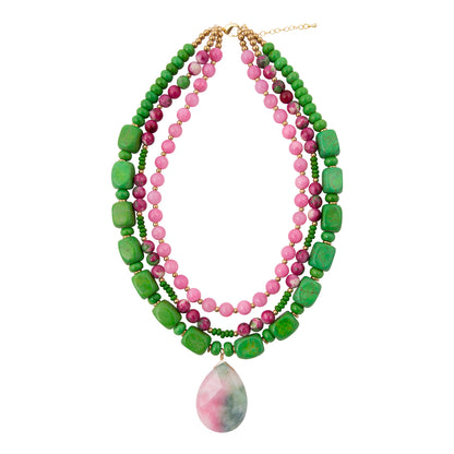 Stack of green and pink beaded necklaces with a pendant on a white background