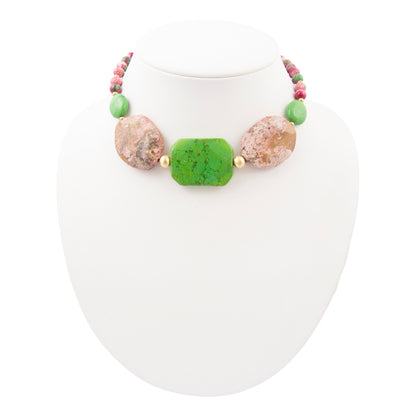 Necklace with green and brown beads on a white stand