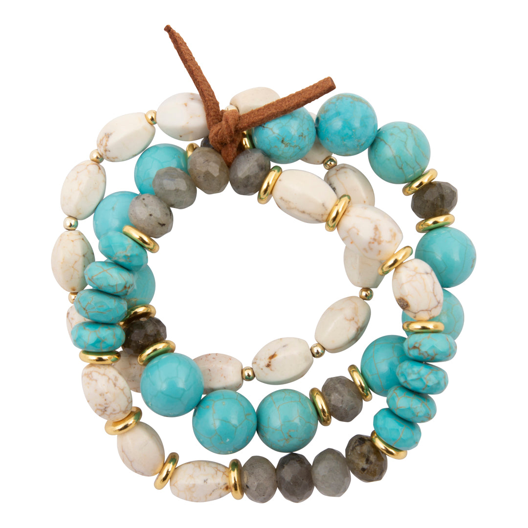 A multi-strand beaded wrap bracelet featuring turquoise blue, white, gray, and brown stones separated by small gold spacer rings, with a brown leather tie at the top, shown on a plain white background.