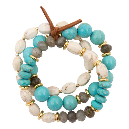 A multi-strand beaded wrap bracelet featuring turquoise blue, white, gray, and brown stones separated by small gold spacer rings, with a brown leather tie at the top, shown on a plain white background.