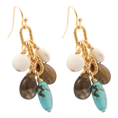A pair of gold dangle earrings featuring white beads, brown teardrop beads, and a prominent turquoise oval bead, shown on a plain white background.