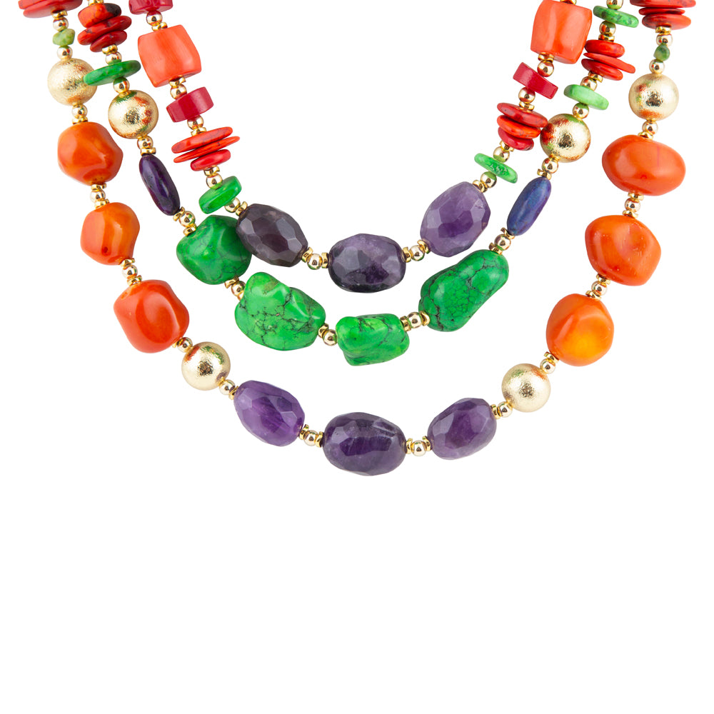 A multi-strand beaded necklace featuring natural stone beads in orange, green, purple, and red, interspersed with small gold metallic beads, shown against a plain white background.