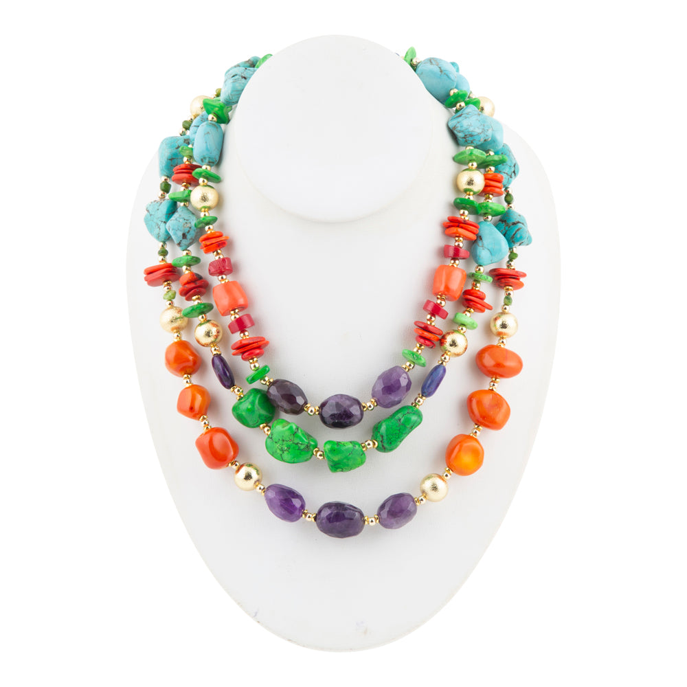 A multi-strand beaded necklace displayed on a white mannequin bust. The necklace features a mix of turquoise blue, green, purple, and orange beads, accented with small gold spacer beads.