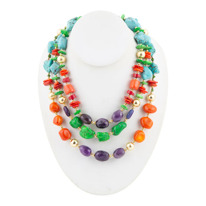 A multi-strand beaded necklace displayed on a white mannequin bust. The necklace features a mix of turquoise blue, green, purple, and orange beads, accented with small gold spacer beads.