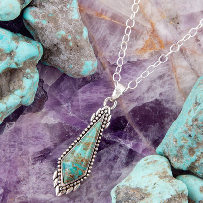 Turquoise pendant necklace on a purple crystal background