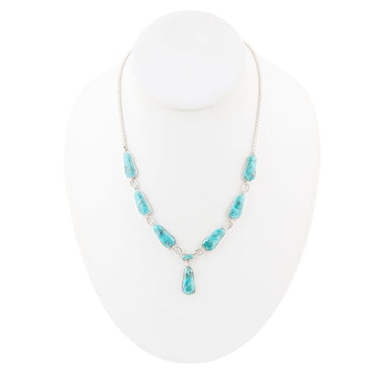 Turquoise necklace on a white stand with a white background