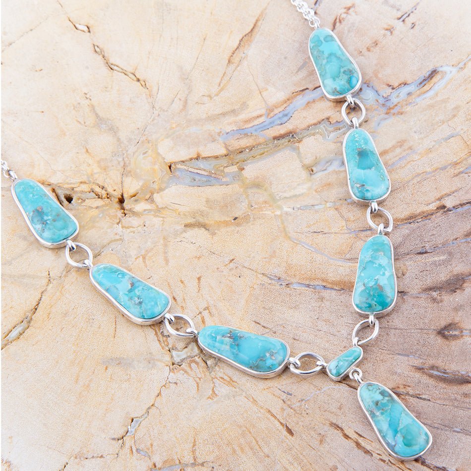 Turquoise necklace on a textured beige surface