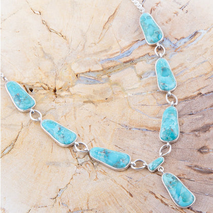Turquoise necklace on a textured beige surface