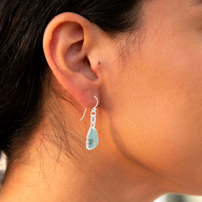 Close-up of an ear wearing a unique earring with a blurred background
