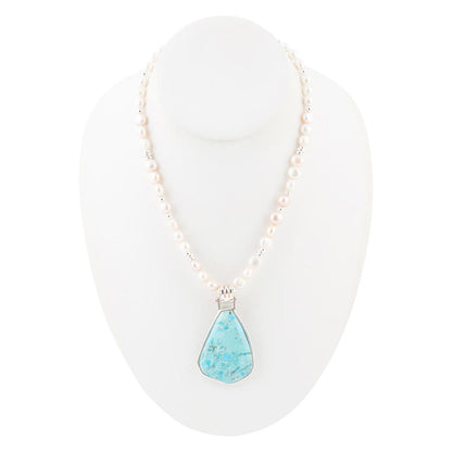 Necklace with a turquoise pendant on a white stand