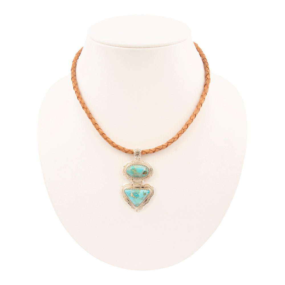 Turquoise heart-shaped pendant on a braided leather cord against a white background