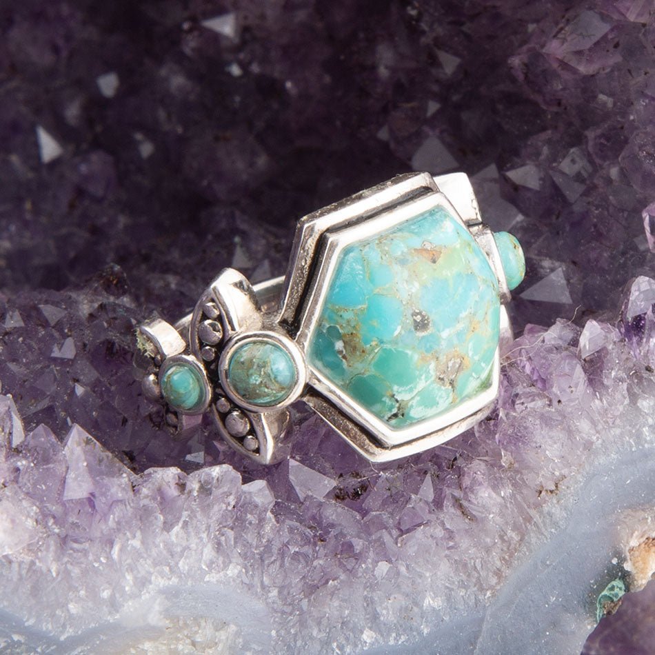 Silver ring with turquoise stones on a crystal background