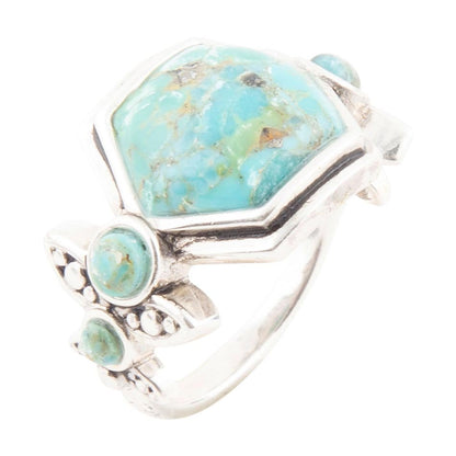 Turquoise stone ring with silver band on a white background