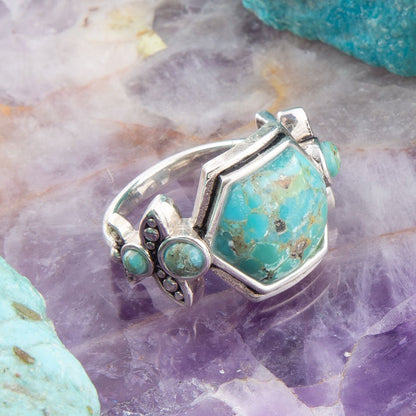 Silver ring with turquoise stones on a textured stone background